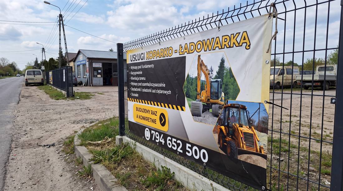 Siatka reklamowa na płot — usługi koparko-ładowarką